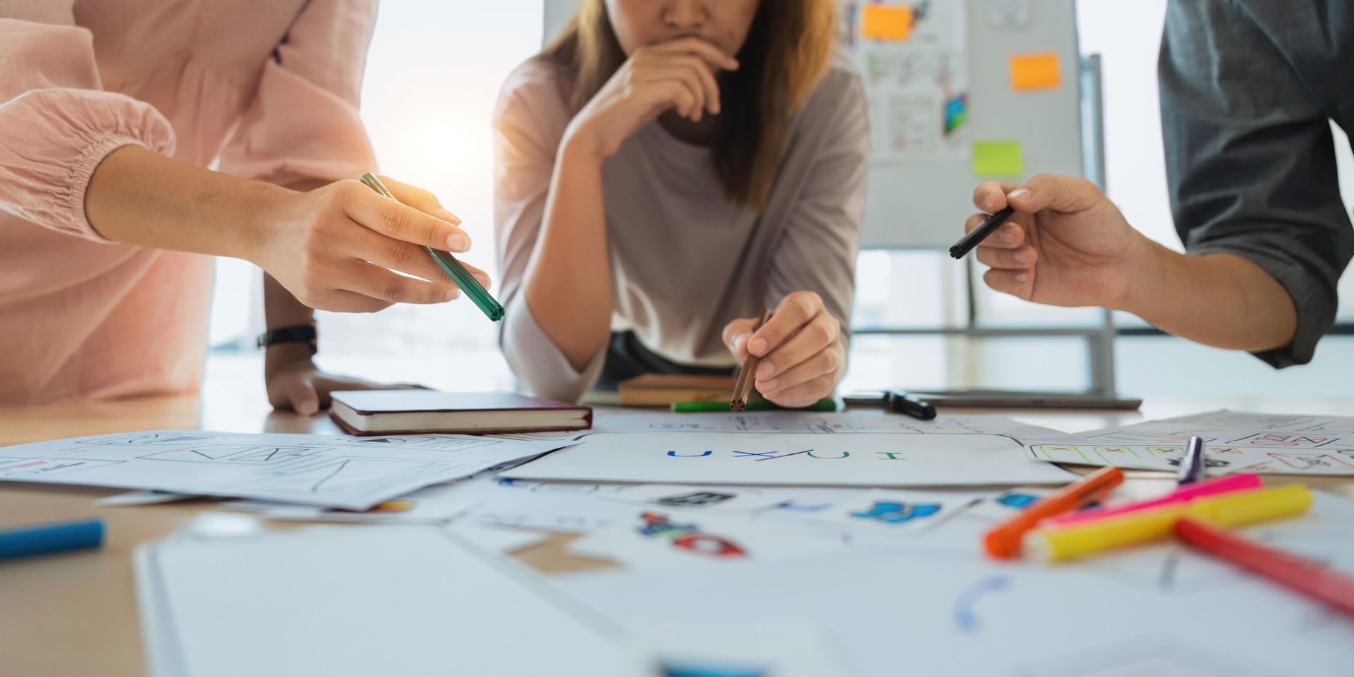 a team standing around a table designing a service and brainstorming